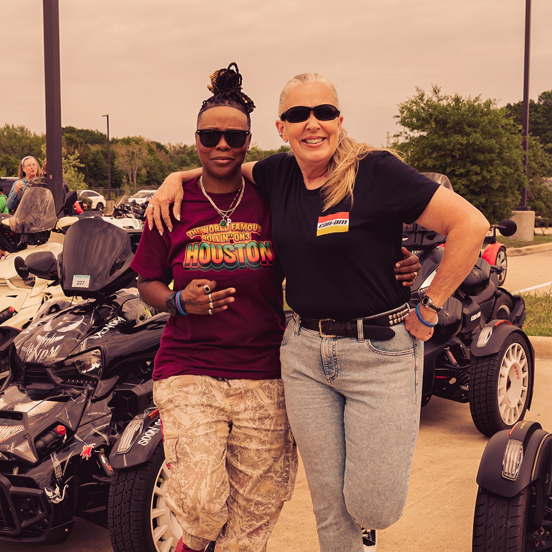 Two women standing in front of a customized Can‑Am Ryker